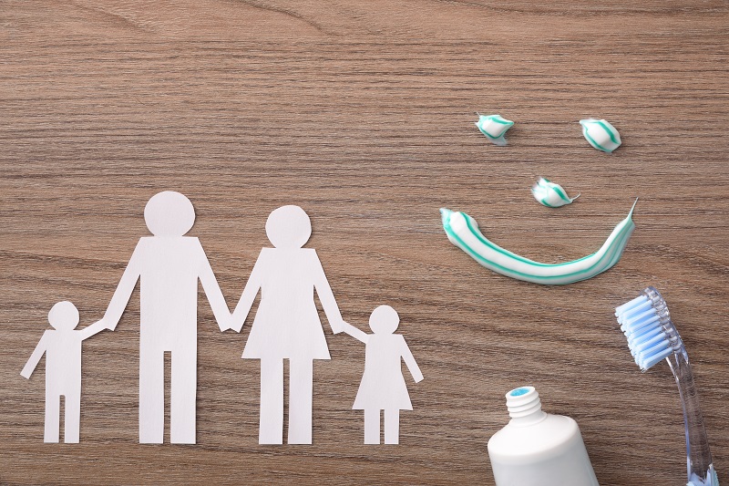 Concept of family dental insurance with representative elements on wood
